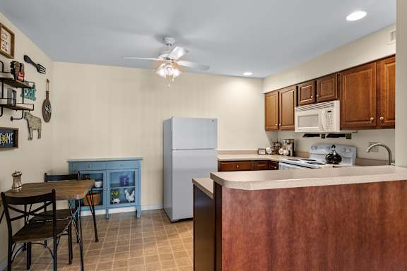 A kitchen with a table and chairs.