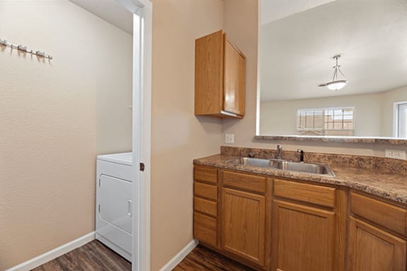 A bathroom with a brown wooden cabinet and a white sink.