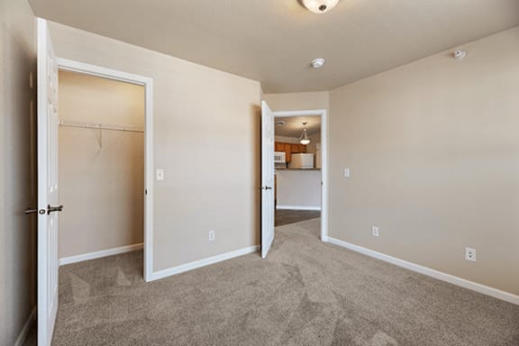 A room with a carpeted floor and a doorway leading to another room.