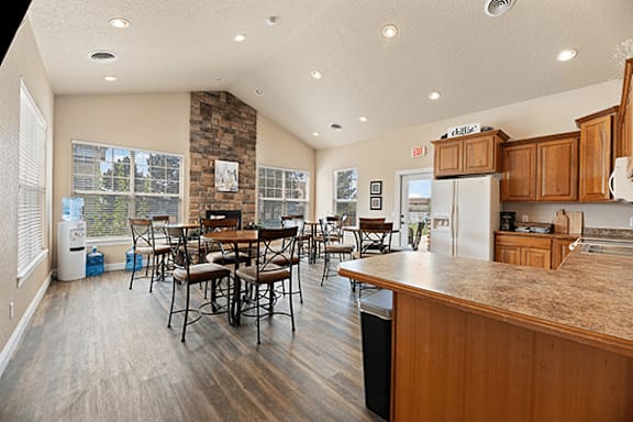 A kitchen and dining area with wooden floors and a stone pillar.