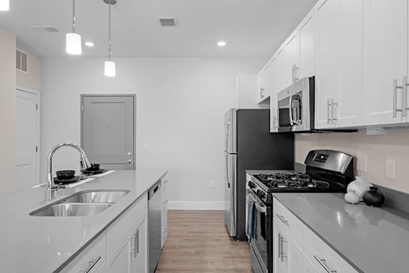 A modern kitchen with white cabinets and stainless steel appliances.