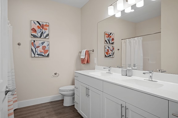 A bathroom with a toilet, sink, and mirror.
