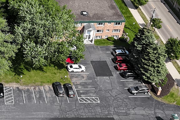 A parking lot with cars and a building in the background.