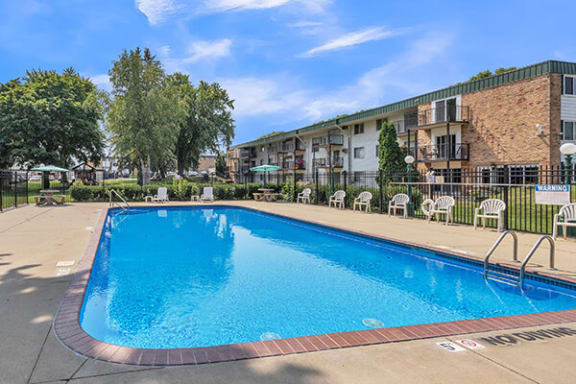 a large swimming pool in front of an apartment building