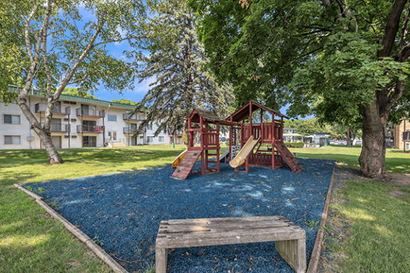 a playground with a swing set and a picnic table