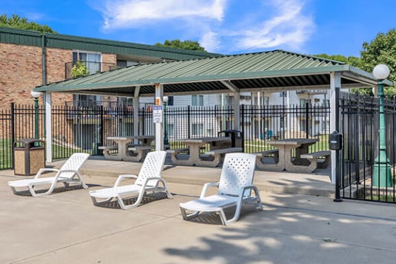 a patio with chairs and tables in front of a building