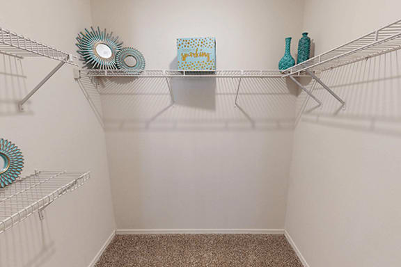 A white shelf with a blue vase and a green box on it.