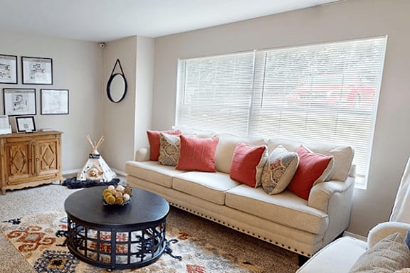 A living room with a white couch and a coffee table.