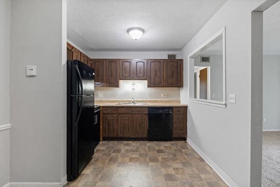 a kitchen with a black refrigerator and a sink