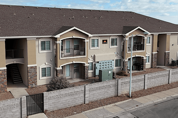 Apartment building with brown roof and grey walls.