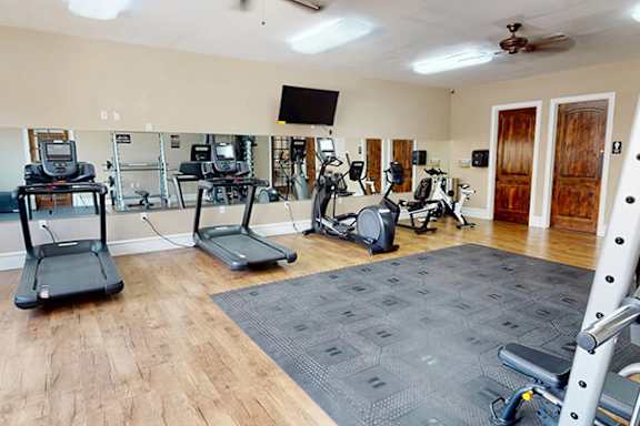 A spacious home gym with a variety of exercise equipment.