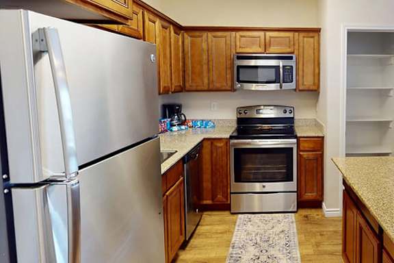 A kitchen with a stainless steel refrigerator and a stainless steel oven.