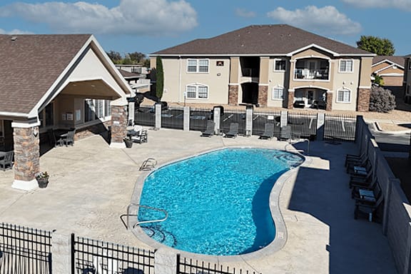 A swimming pool in a backyard with a black fence.