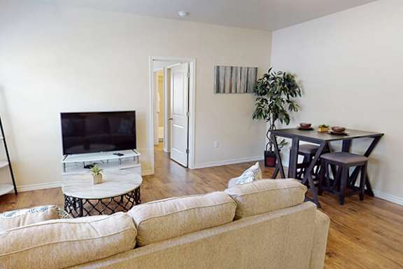 A living room with a couch, a television, and a coffee table.