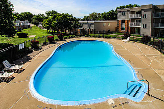 a large swimming pool with an apartment building in the background