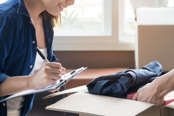 a woman writing on a notepad with a man sitting next to her