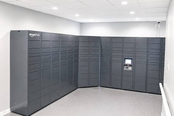 A row of Amazon hubs for packages lined up in a room.