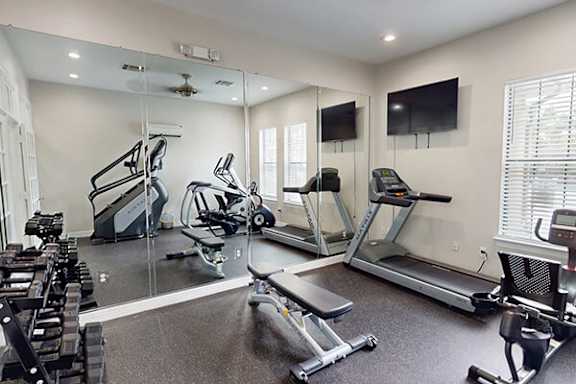 A spacious home gym with a variety of exercise equipment.