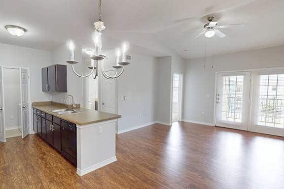 A kitchen with a wooden floor and a chandelier.