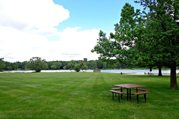 a picnic table at lamberton lake apartments next to a lake