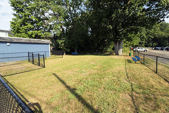 A backyard with a fence and a blue bench.