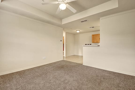 A room with a ceiling fan and carpeted floor.