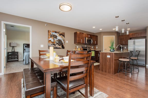 A modern dining room with a wooden table and chairs.