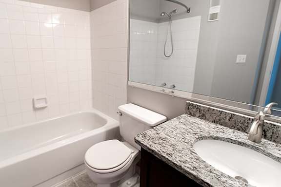 A white toilet sits next to a bathtub in a bathroom.