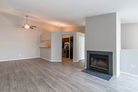A living room with a fireplace and a ceiling fan.
