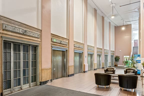 a large lobby with tables and chairs and tall ceilings