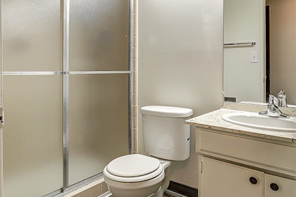 A white toilet sits next to a sink in a bathroom.