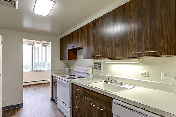 A kitchen with white appliances and wooden cabinets.