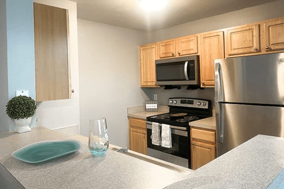 a kitchen with wood cabinets and stainless steel appliances