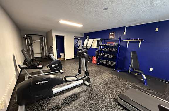 A gym with treadmills, weights, and exercise equipment.
