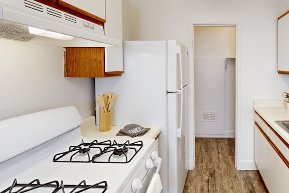 A small kitchen with a white stove and a white refrigerator.