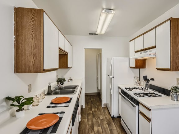 galley style kitchen with oven and dishwasher at mesa gardens apartment