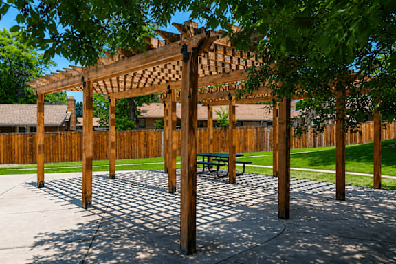 A wooden pergola with a bench underneath it.