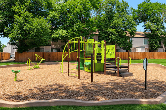 A playground with a green swing set and a yellow slide.