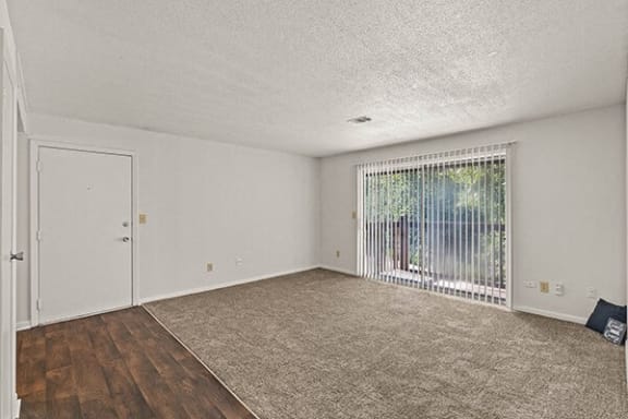 an empty living room with a window and a door
