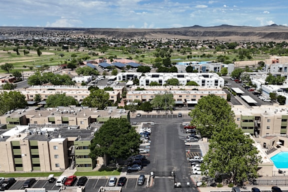 A parking lot is in the foreground of a city scene.
