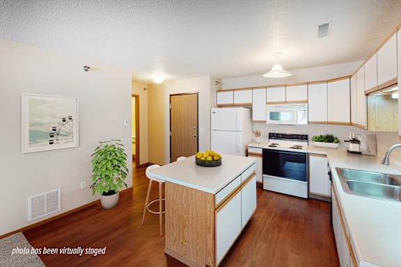 A kitchen with a white fridge and wooden cabinets.