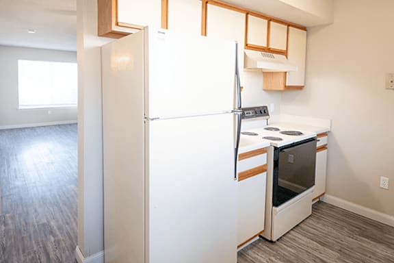 A white refrigerator with a drawer in the door is in a kitchen.