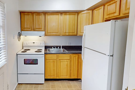 A kitchen with wooden cabinets and a white refrigerator.