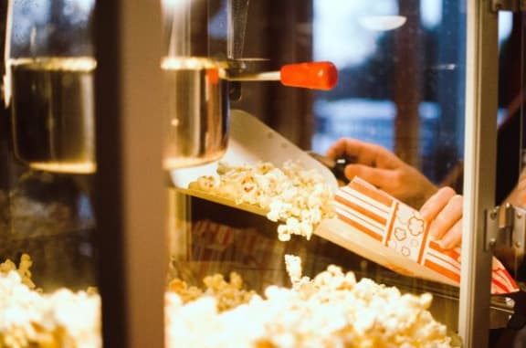 a person putting a box of popcorn into a machine