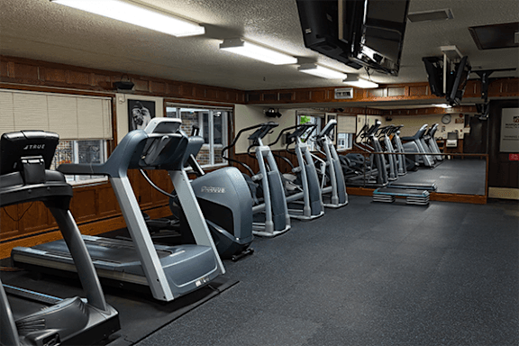 A gym with treadmills and elliptical machines.