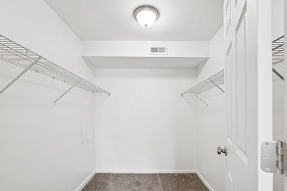 A white room with a door and a light on the ceiling.