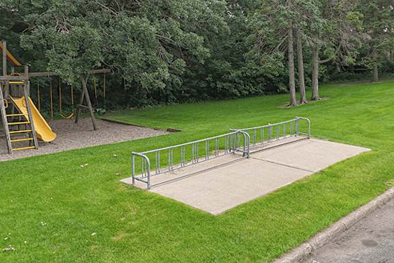 A playground with a slide and a metal railing.