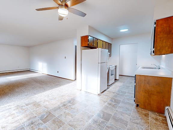 A kitchen with a tile floor and a ceiling fan.