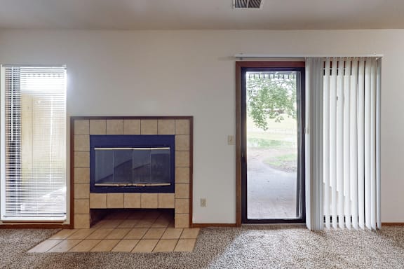 A living room with a fireplace and sliding glass doors.