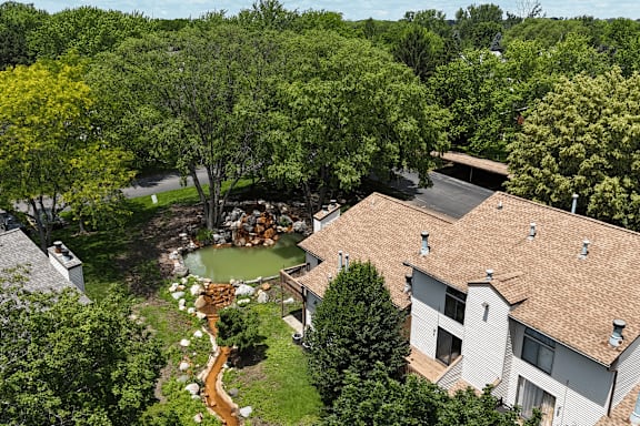 A house with a brown roof is surrounded by trees.